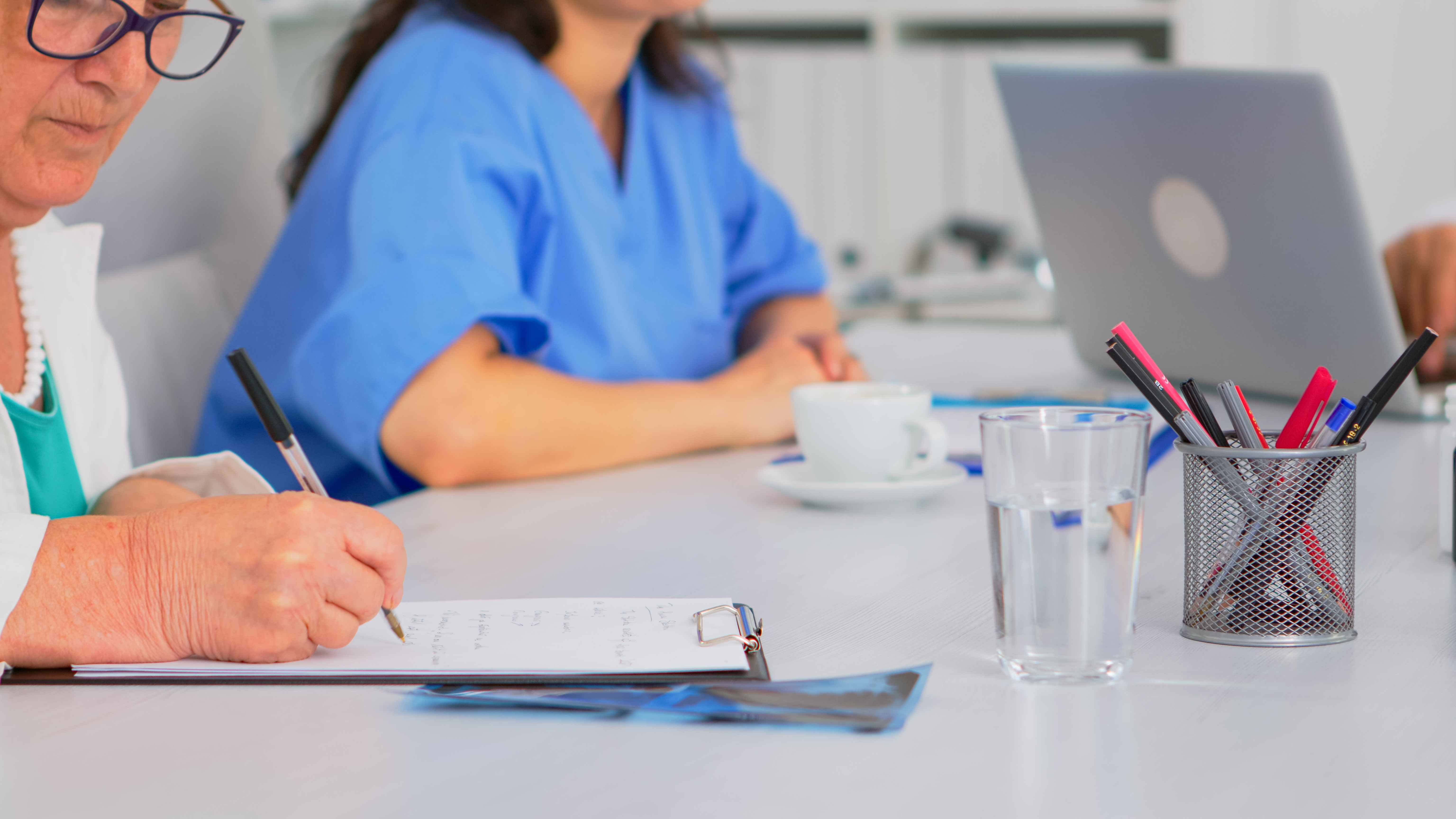 Health professionals sitting around a table and discussing notes