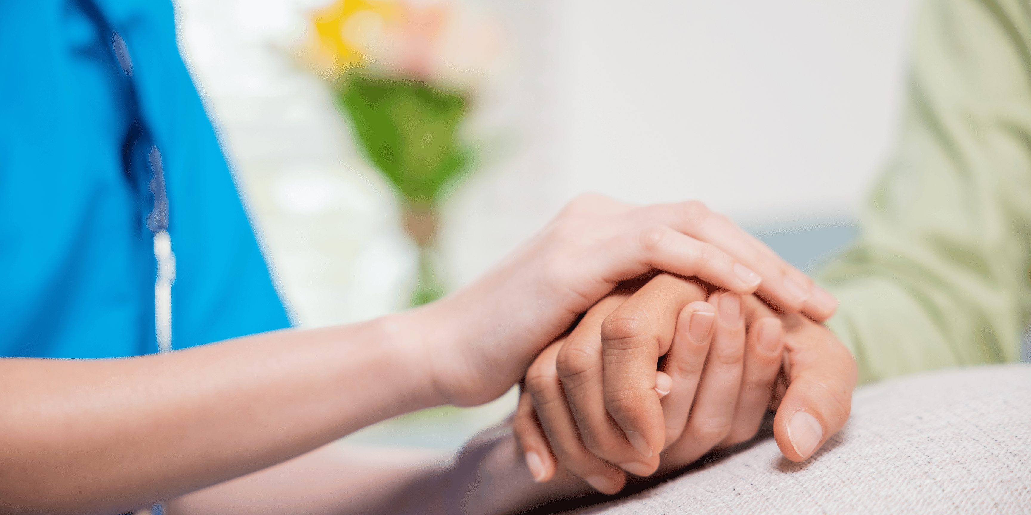 Health professional holding her patient's hand in a sympathetic way