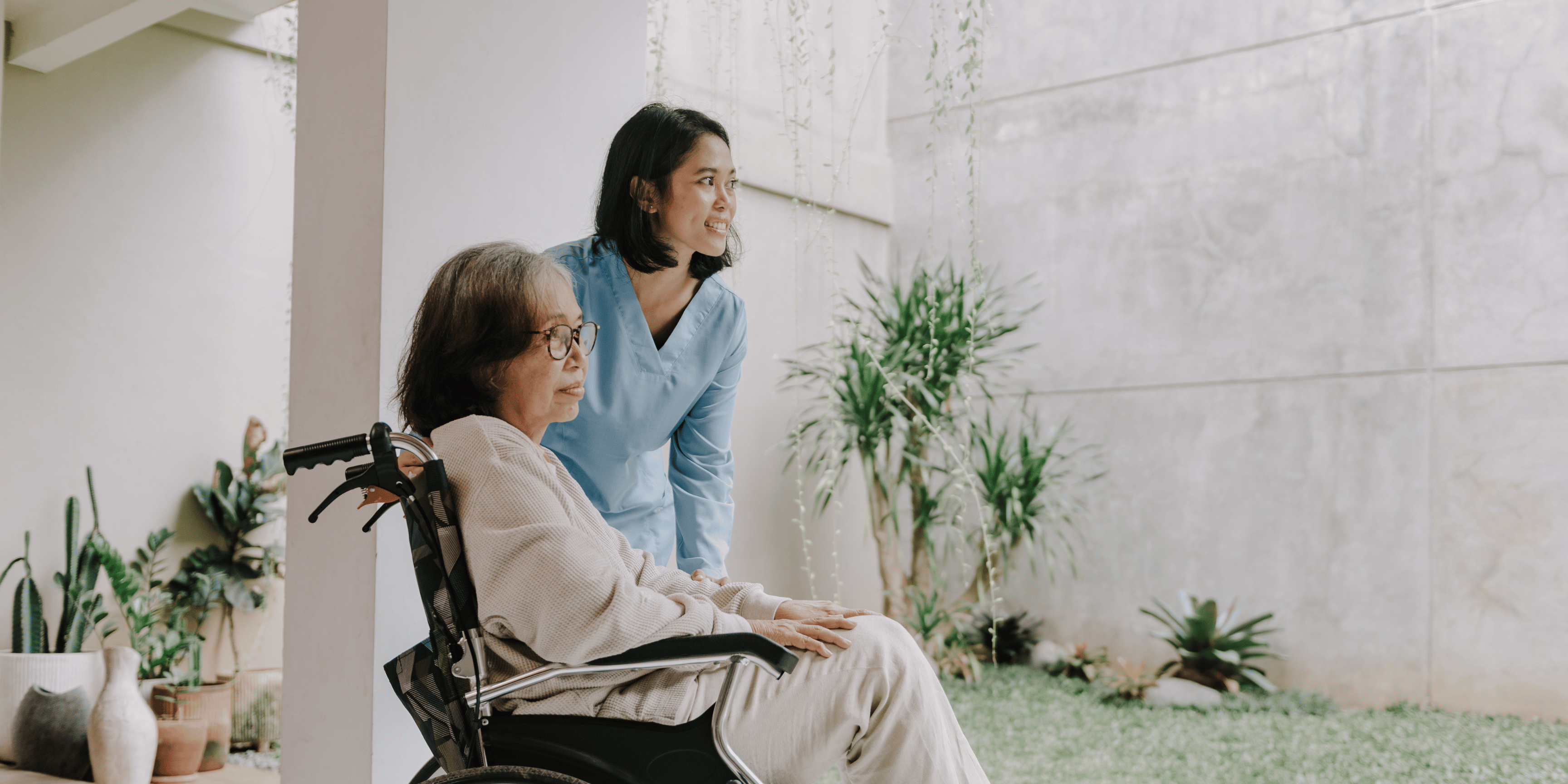 Nurse and client seated by the window, and looking into the distance