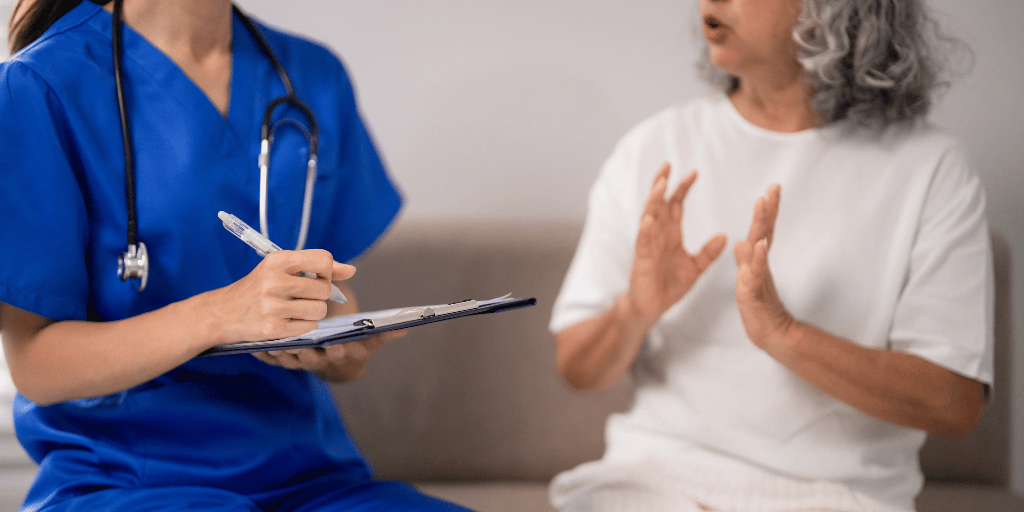 Health professional taking notes while patient explains their symptoms and needs