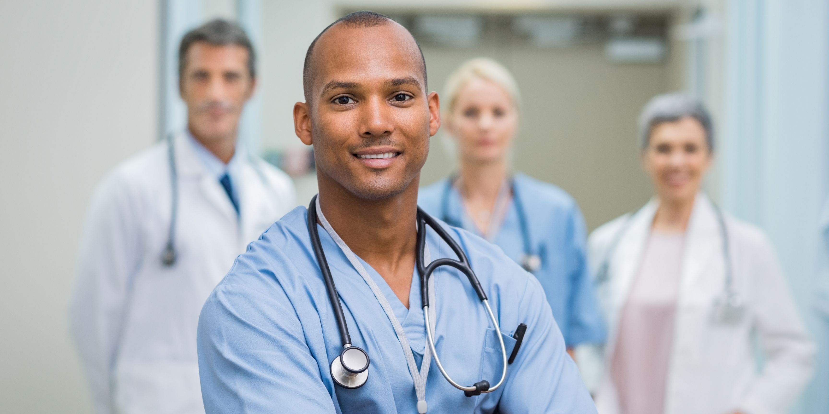 Group of professional looking healthcare workers standing with their arms crossed